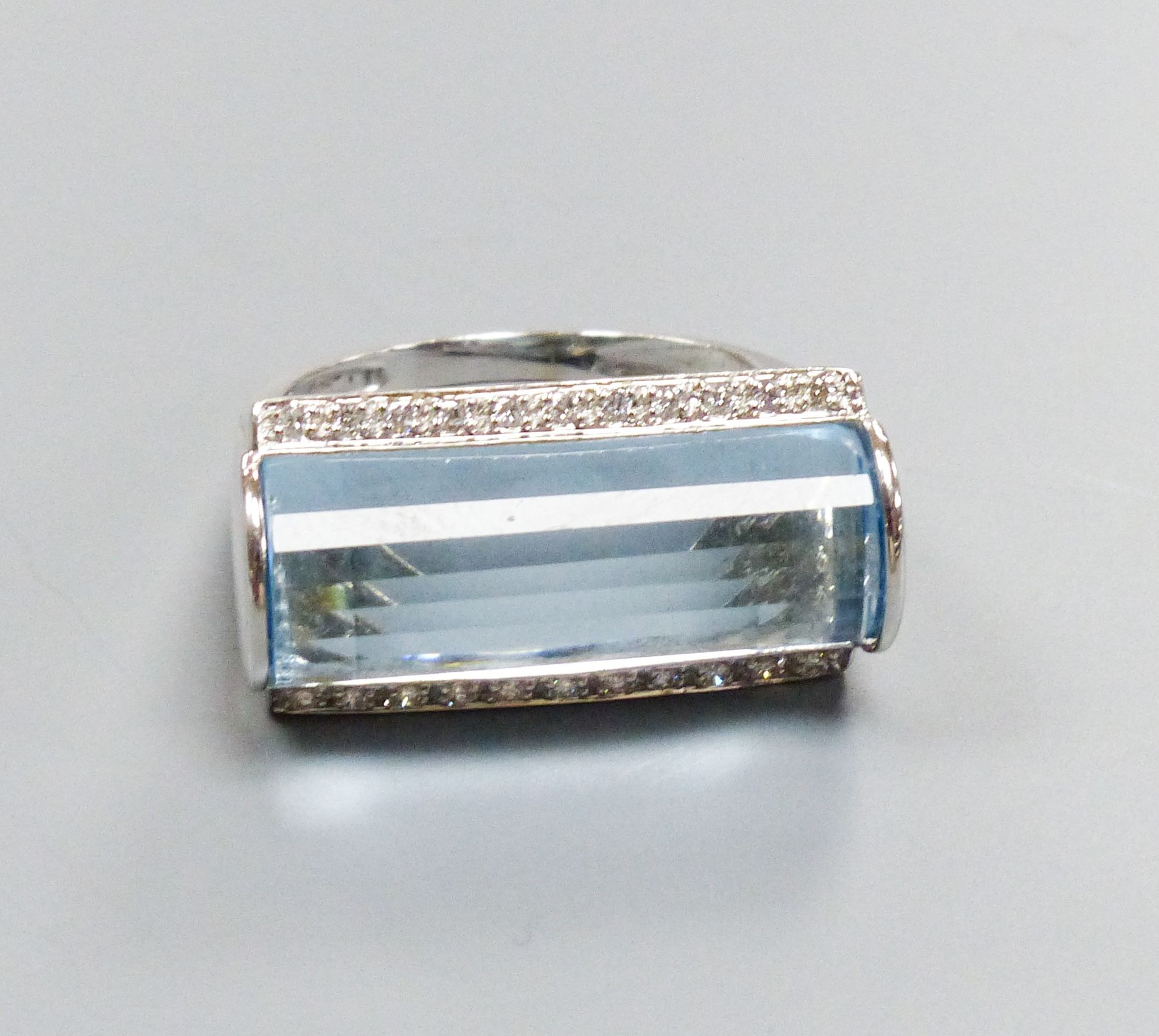 A modern 18k white metal, fancy cut blue topaz and diamond chip set dress ring, size L, gross weight 7.1 grams.